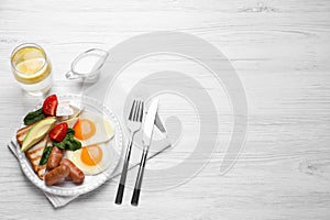 Delicious breakfast with fried eggs served on white wooden table, flat lay. Space for text