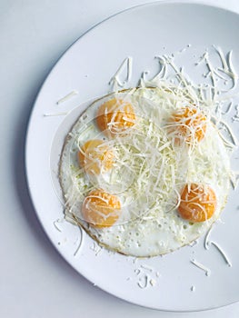 delicious breakfast of fried five eggs and grated cheese.