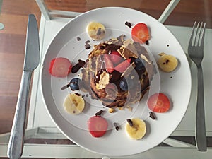 Delicious breakfast of pancakes with chocolate,  red berries, strawberries and blueberries