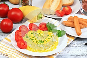 Delicious breakfast of scrambled eggs, baguettes and vegetable