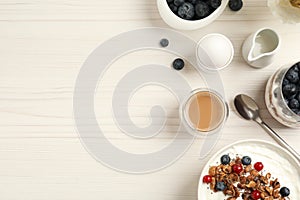 Delicious breakfast served on white wooden table, flat lay. Space for text