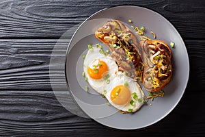 Delicious breakfast of shiitake toasts and fried eggs close-up. horizontal top view