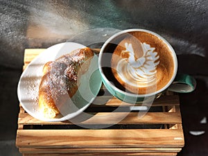 Delicious Breakfast; swan shape Latte art coffee in Green and white cup and Croissant