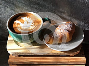 Delicious Breakfast; swan shape Latte art coffee in Green and white cup and Croissant