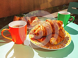 Delicious breakfast with tea on balcony, fresh croissants