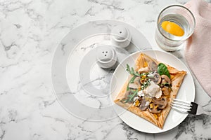 Delicious breakfast with thin pancakes on marble table, flat lay. Space for text