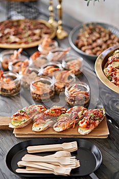 Delicious bruschetta with salmon and canape shrimp on table. Tasty buffet table. Summer party. Catering concept