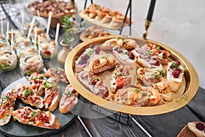 Delicious bruschetta with salmon and canape shrimp on table. Tasty buffet table. Summer party. Catering concept