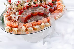 Delicious bruschetta with salmon and canape shrimp on table. Tasty buffet table. Summer party outdoor. Catering concept