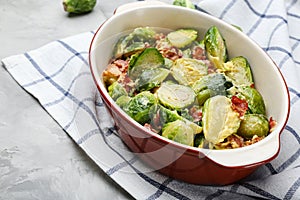 Delicious Brussels sprouts with bacon in baking pan on grey table