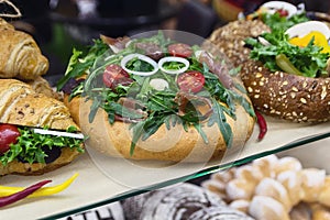 Delicious bun with bacon and vegetables on display at bakery