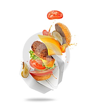 Delicious burger flies out of cardboard packaging isolated on a white background