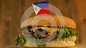 Delicious burger with small Filipino flag on top of them with toothpicks. Yummy hamburger rotating.