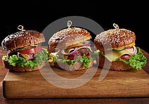 Delicious burgers with fried beef cutlet, tomato, lettuce and onions, crispy white wheat flour bun with sesame seeds