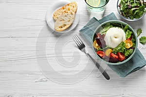 Delicious burrata salad with colorful cherry tomatoes and arugula served on white wooden table, flat lay. Space for text