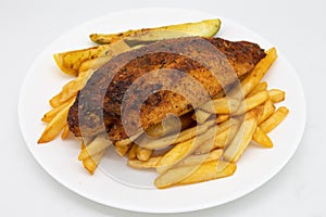 Cajun Blackened Catfish with French Fries on a White Plate photo