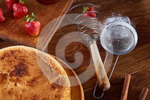 Delicious cake with fresh organic strawberries on cutting board over wooden background, close-up, selctive focus.