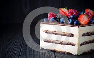 Delicious cake with fruit and berries on wooden table