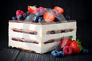 Delicious cake with fruit and berries on wooden table