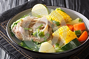 Delicious Caldo de res Mexican beef shank soup with vegetables close-up in a bowl on the table. horizontal
