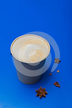 Delicious cappuccino with milk on a blue background. close-up