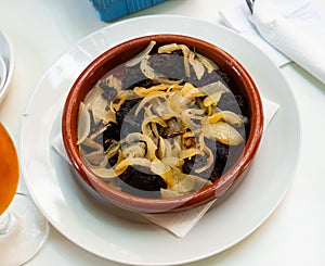 Delicious Catalan blood sausages with grilled onion served on plate. Morcilla con cebolla photo