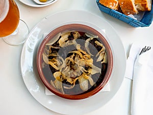 Delicious Catalan blood sausages with grilled onion served on plate. Morcilla con cebolla photo