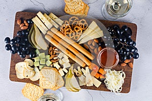 Delicious cheese mix with grapes, jam, snacks, crackers, walnuts