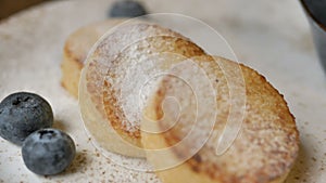 Delicious cheese pancakes cowered with sugar powder on plate