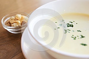 Delicious cheese soup. White dishes. Small crackers