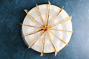 Delicious cheesecake with coconut closeup on blue marble background top view. cheesecake portion cutting dessert closeup