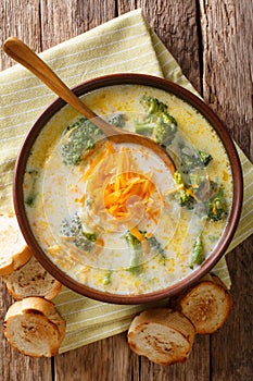 Delicious cheesy broccoli soup with vegetables in a bowl with to