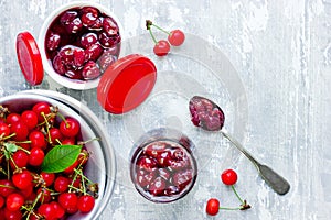 Delicious cherry jam in sugar syrup and fresh cherries in bowl