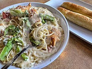 Delicious chicken carbonara entree served with two breadsticks