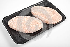 Raw delicious chicken cutlet in package. on a white background.