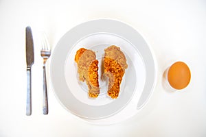 Delicious chicken fried and egg is placed in white dish