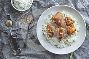 Delicious chicken with sweet and sour orange sauce accompanied by jasmine rice Chinese-style recipe, top view.