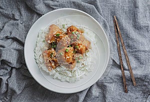 Delicious chicken with sweet and sour orange sauce accompanied by jasmine rice Chinese-style recipe, top view.