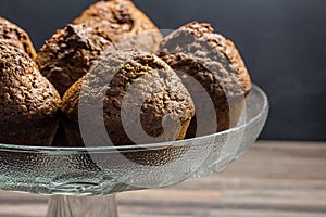 Delicious chocolate banana muffins in glass cake stand with copy space - chocolate muffin background