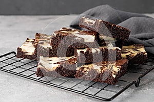 Delicious chocolate brownie cheesecake on a gray concrete background. Copy space, selective focus