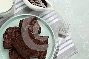 Delicious chocolate brownies with nuts on light grey table, flat lay