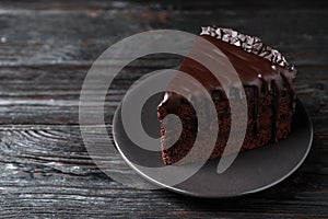 Delicious chocolate cake on black wooden table