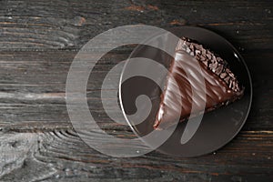 Delicious chocolate cake on black wooden table, top view. Space for text