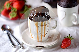 Delicious Chocolate cake cooked in a microwave in a mug with caramel syrup.