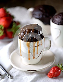 Delicious Chocolate cake cooked in a microwave in a mug with caramel syrup.