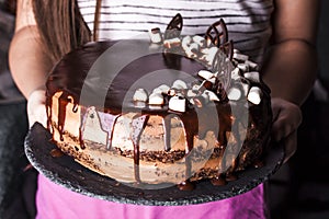 Delicious chocolate cake in white plate on wooden table background