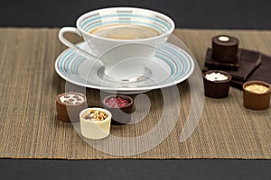 Delicious chocolate candies with vintage cup of coffee