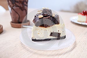 Delicious chocolate cheesecake slice with walnuts on white plate