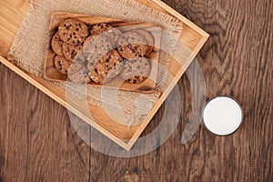 Delicious chocolate chip cookies on a tray on dark old wooden ta