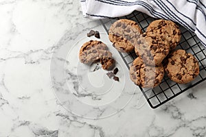 Delicious chocolate chip cookies on white marble table, flat lay. Space for text